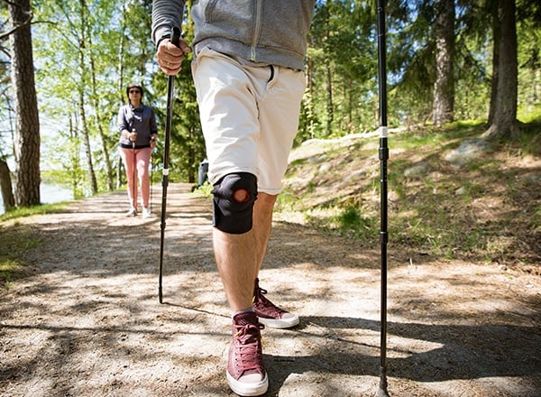 Man wearing knee brace while hiking outdoors