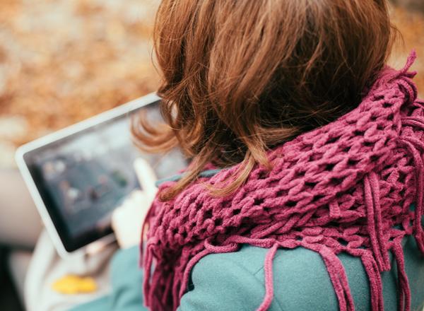 woman sitting on a bench and reading a blog post