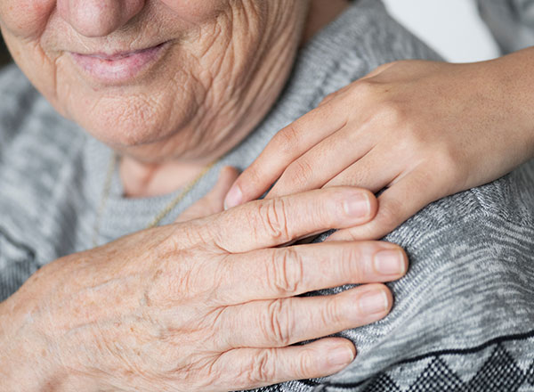 Child's hand on elderly woman's shoulder