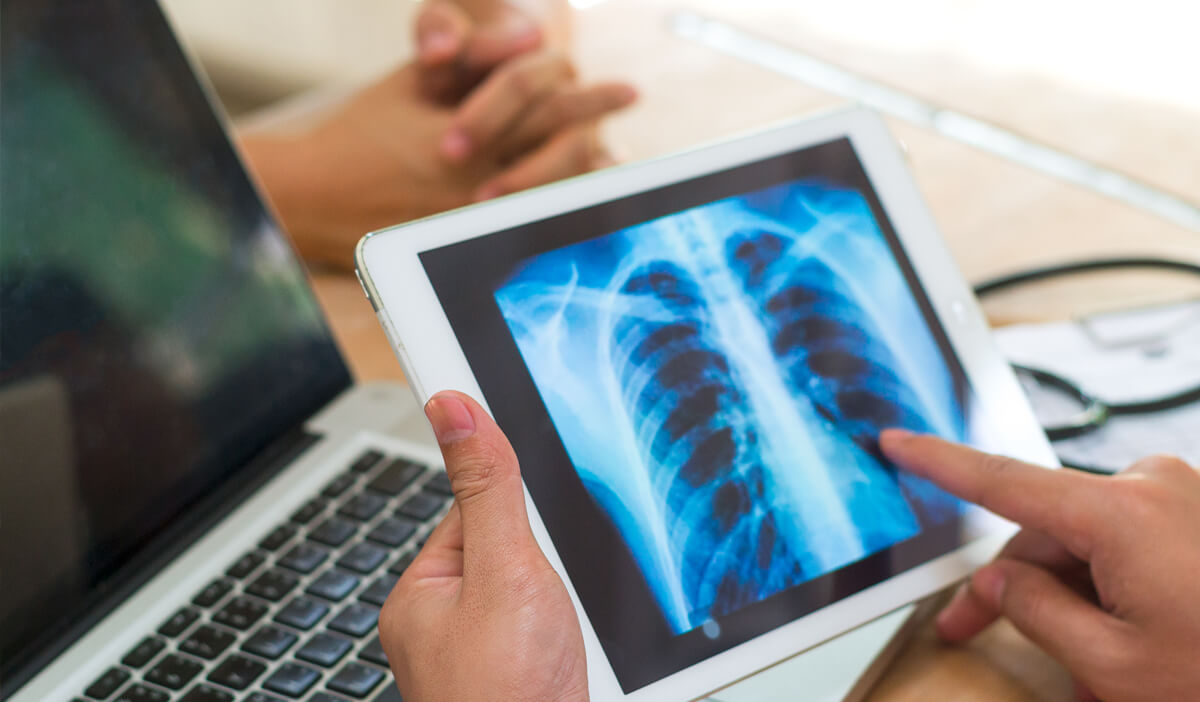 Doctor using ipad to look at medical imaging exam results