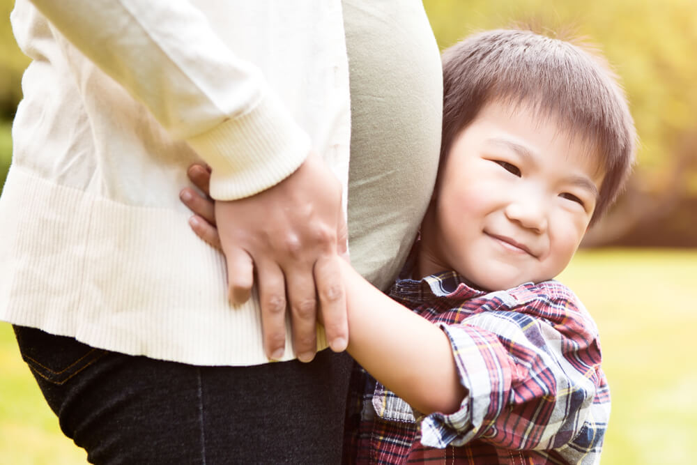 son hugs his pregnant mother