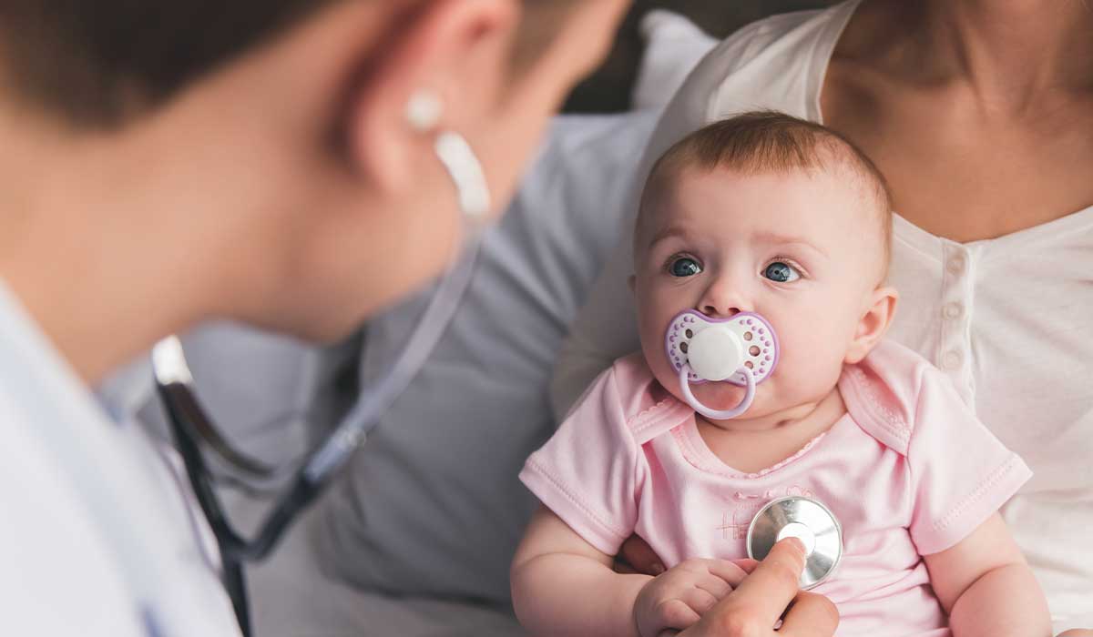 pediatrician listening to a baby’s heartbeat