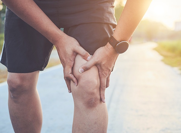 Runner holding knee in pain