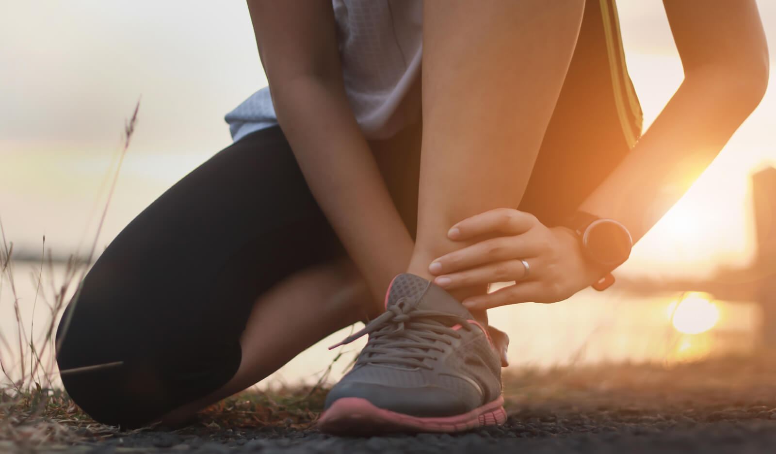 athlete holding her sore ankle