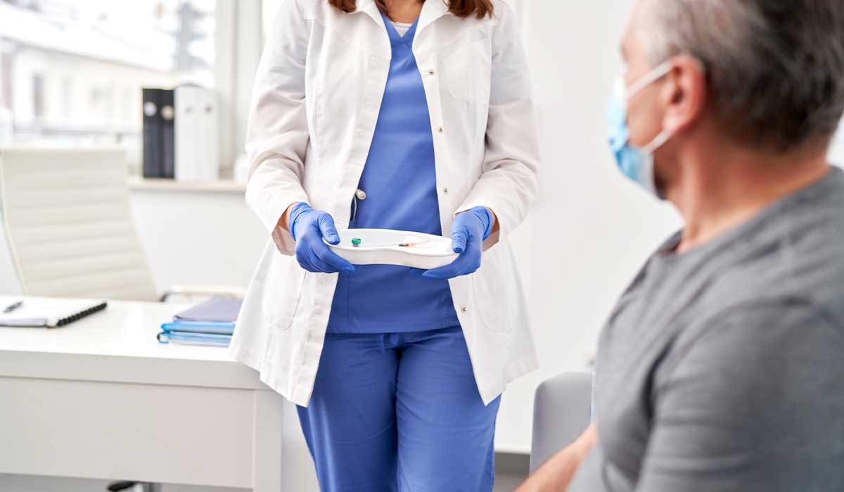 man looks at nurse during an appointment to determine if he has any urologic diseases