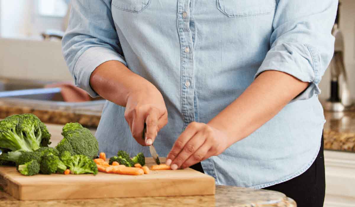 woman chops vegetables to fuel her body