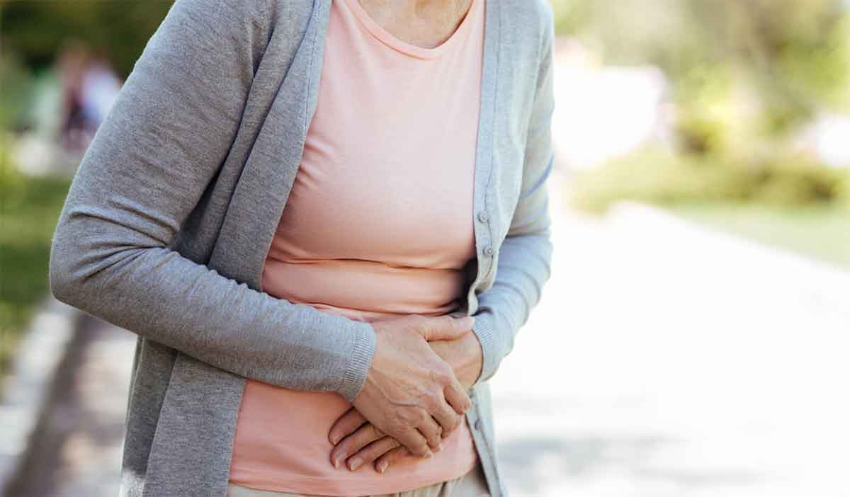 Woman holds her stomach in pain